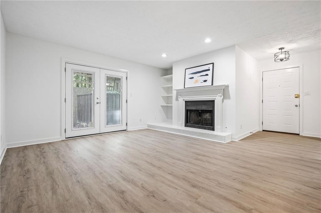 102 River Run Drive Atlanta, GA 30350 - Photo 13 of 28 an empty room with wooden floor fireplace and cabinet