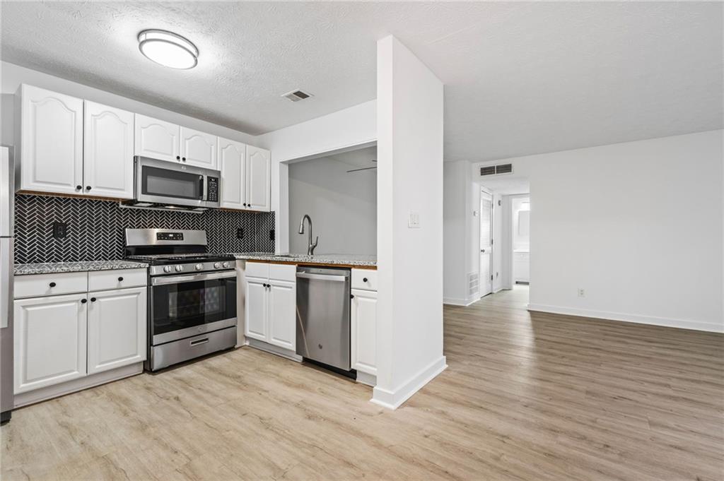 102 River Run Drive Atlanta, GA 30350 - Photo 7 of 28 a kitchen with granite countertop a refrigerator and a stove top oven