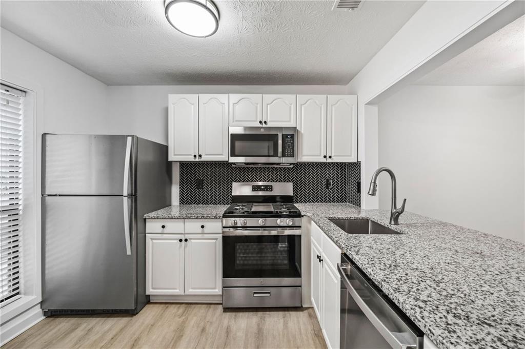 102 River Run Drive Atlanta, GA 30350 - Photo 8 of 28 a kitchen with a stove a refrigerator and a sink