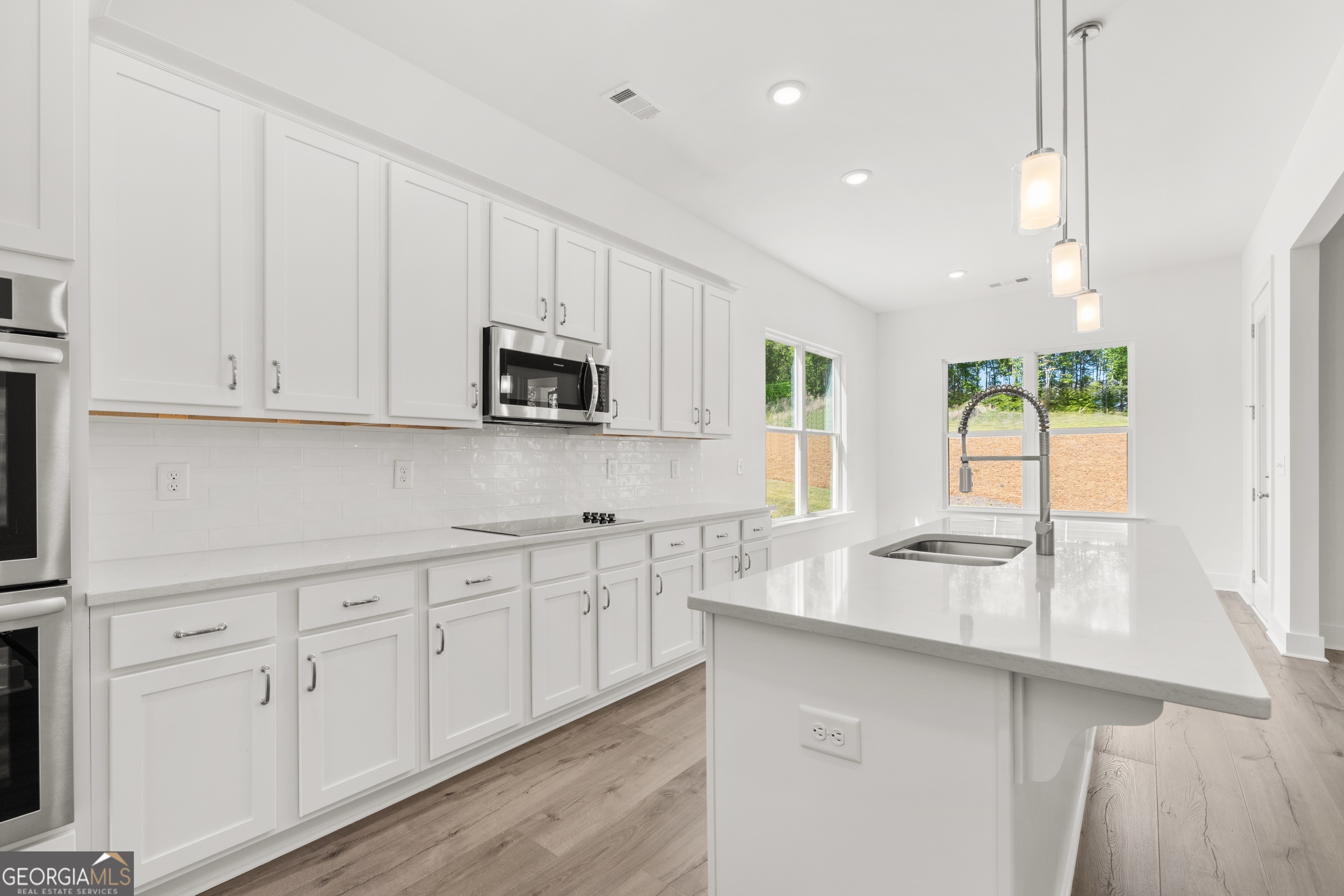 15 Overview Court Hoschton, GA 30548 - Photo 14 of 43 a kitchen with white cabinets and window