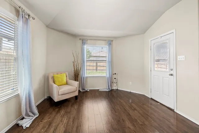 a view of a livingroom with wooden floor and a window