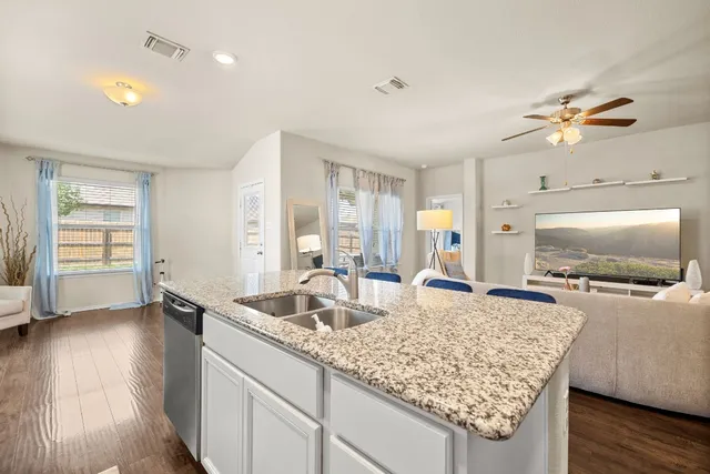 a living room with granite countertop furniture and a flat screen tv
