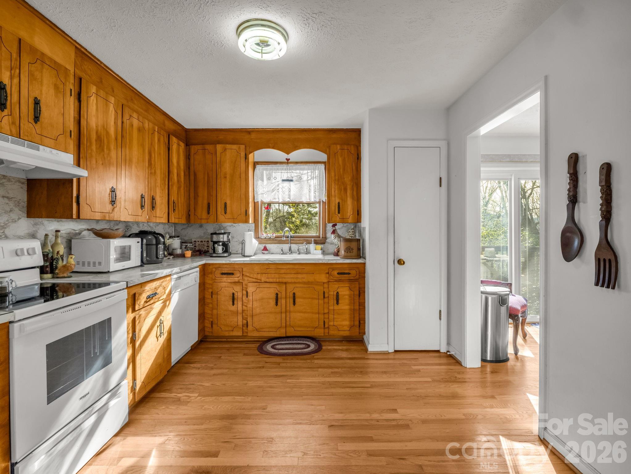 755 Mt Olivet Road Zirconia, NC 28790 - Photo 12 of 35 a kitchen with stainless steel appliances a stove top oven a sink a refrigerator and cabinets