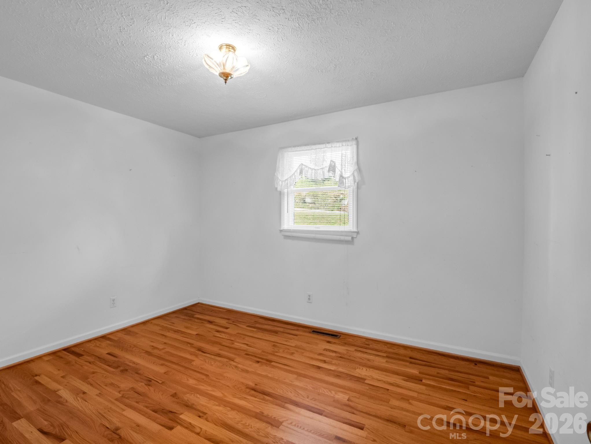 755 Mt Olivet Road Zirconia, NC 28790 - Photo 18 of 35 an empty room with wooden floor and windows