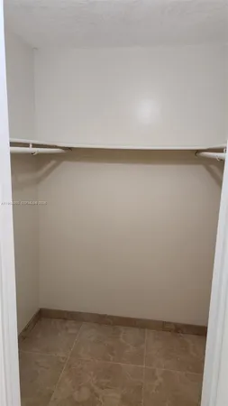 a view of a hallway with closet and a mirror