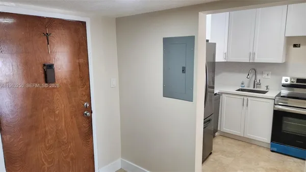 a view of a kitchen with white cabinets and stainless steel appliances