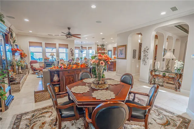 a kitchen with stainless steel appliances granite countertop a table chairs and a refrigerator