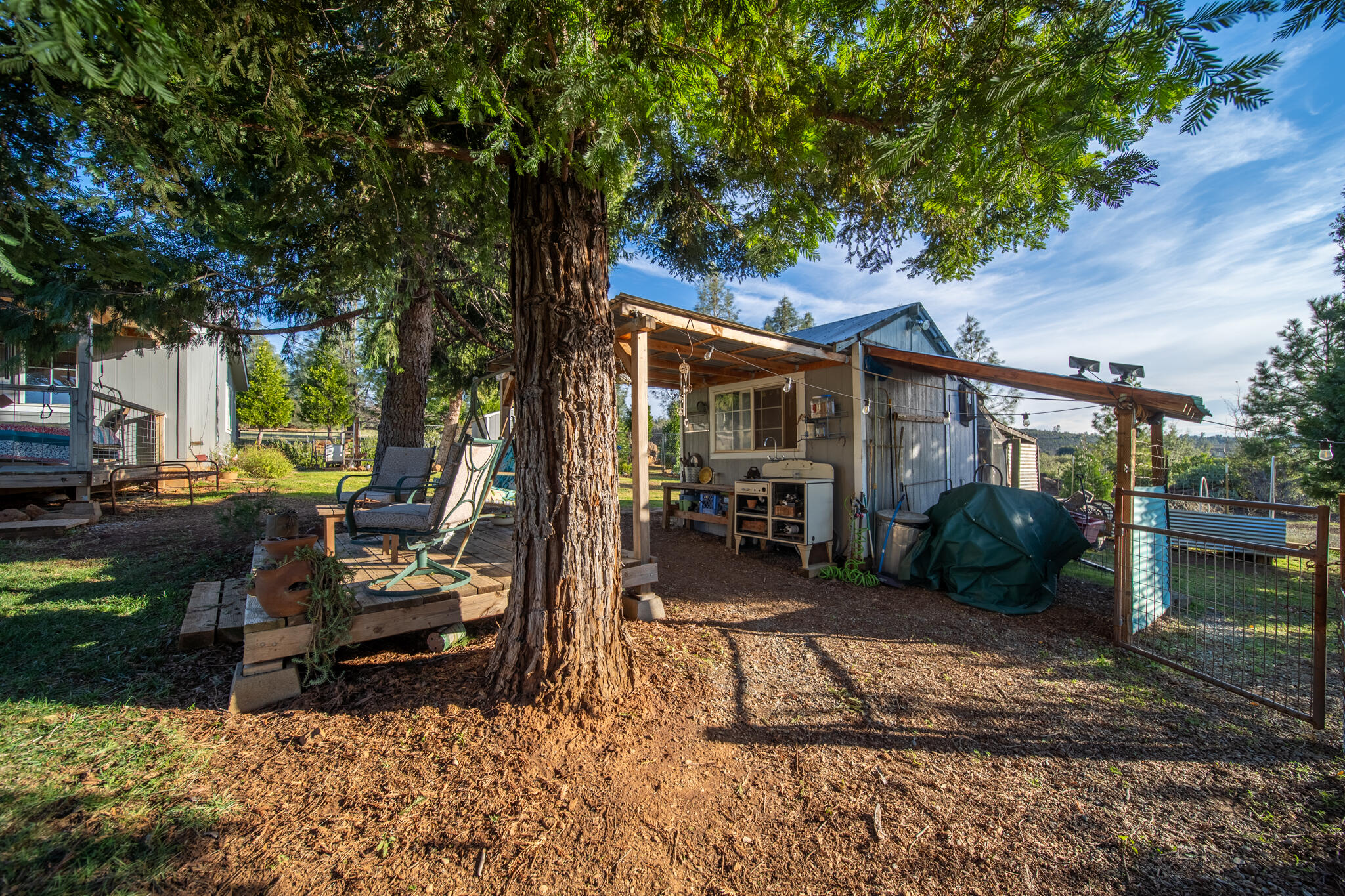 32017 Rock Creek Road Manton, CA 96059 - Photo 28 of 57 a view of a patio with table and chairs a barbeque with wooden fence