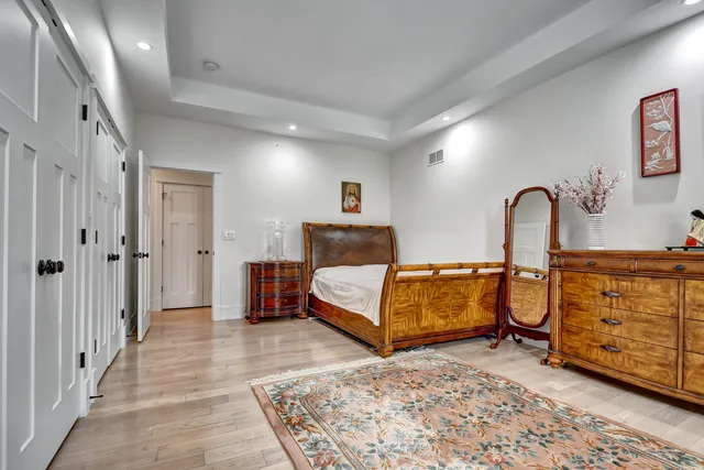 a bedroom with a bed and dresser with mirror