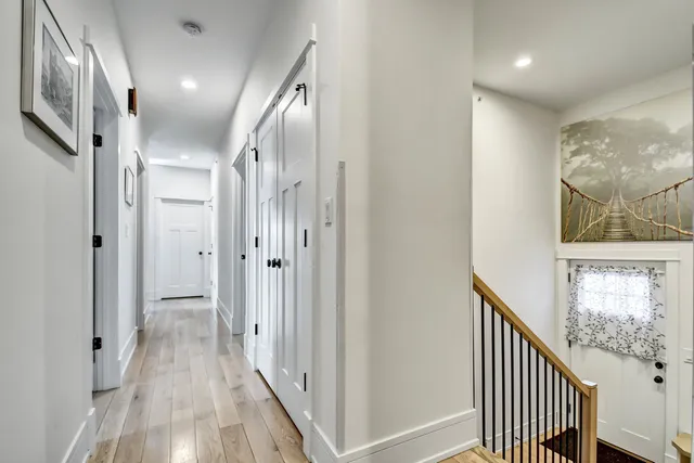 a view of a hallway with wooden floor and staircase