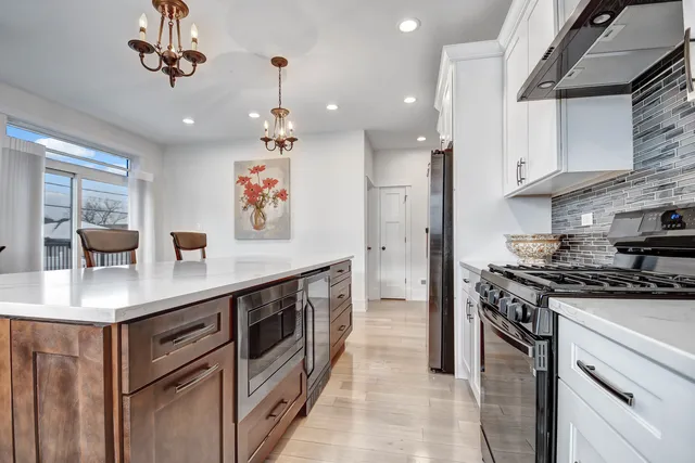 a kitchen with stainless steel appliances granite countertop a sink a stove and a refrigerator