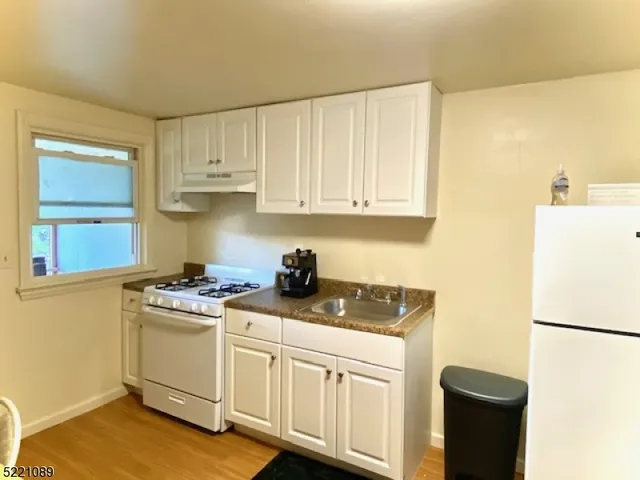 a kitchen with cabinets appliances a sink and a counter top space