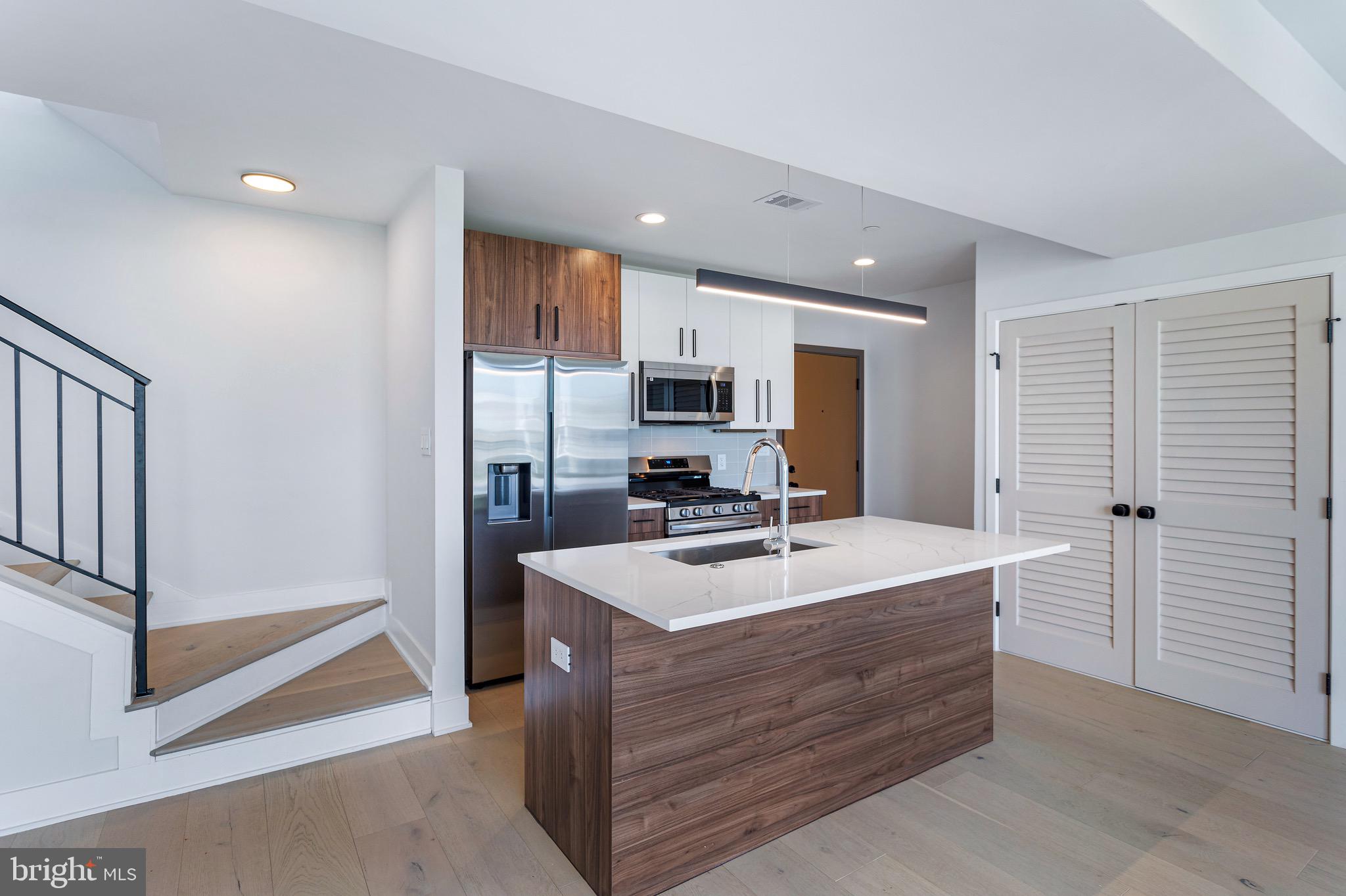 a kitchen with sink refrigerator and microwave
