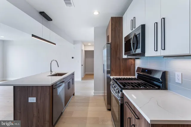 a kitchen with stainless steel appliances granite countertop a sink stove and cabinets
