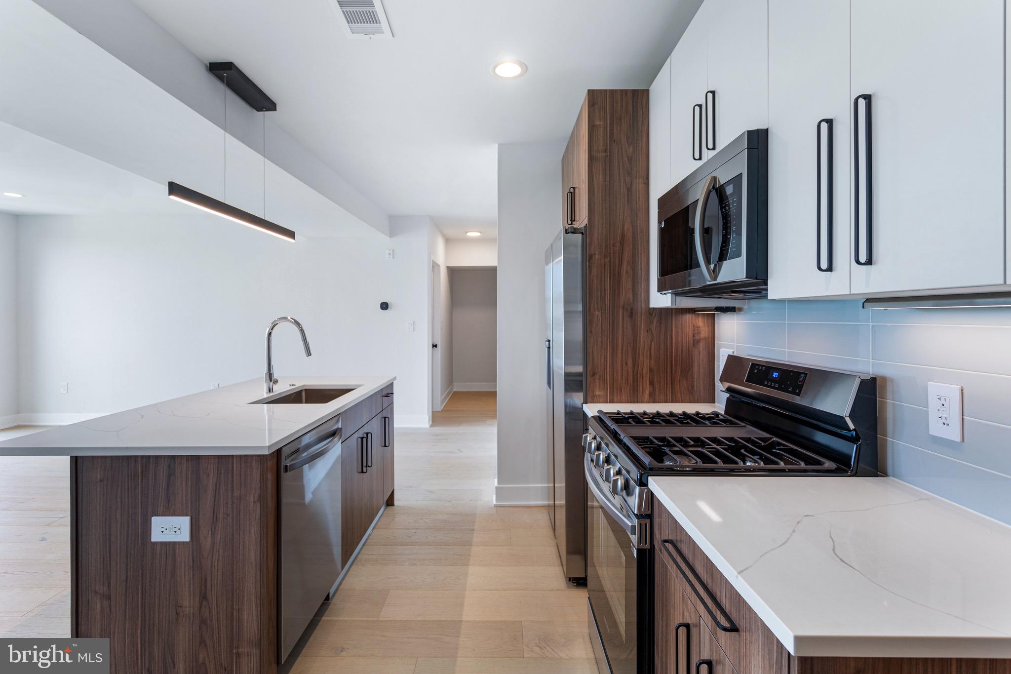 845 19th Street Northeast, Unit PH12 Washington, DC 20002 - Photo 3 of 24 a kitchen with stainless steel appliances granite countertop a sink stove and cabinets