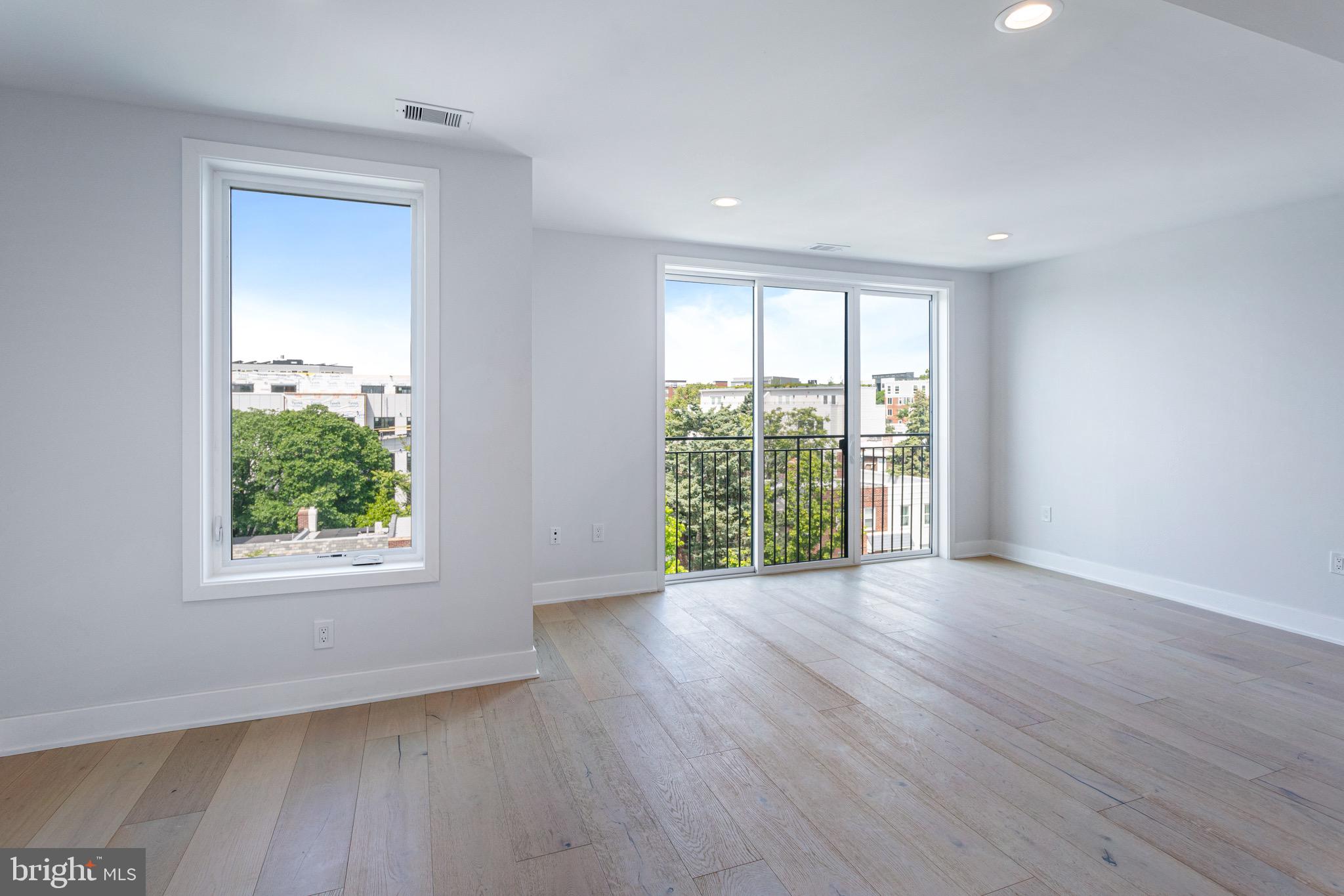 845 19th Street Northeast, Unit PH12 Washington, DC 20002 - Photo 5 of 24 a view of an empty room with wooden floor and a window