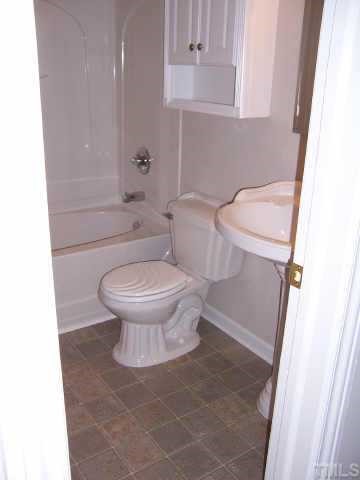 824 North King Charles Road Raleigh, NC 27610 - Photo 6 of 7 a white toilet sitting next to a bathroom sink and vanity