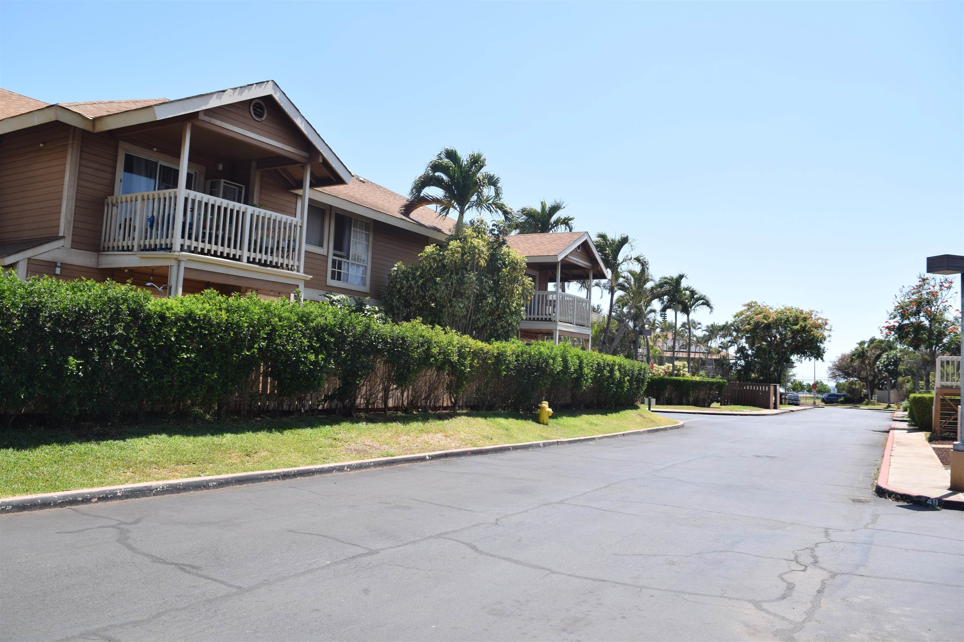 140 Uwapo Road, Unit 41203 Kihei, HI 96753 - Photo 3 of 17 a view of a house with a yard and large trees