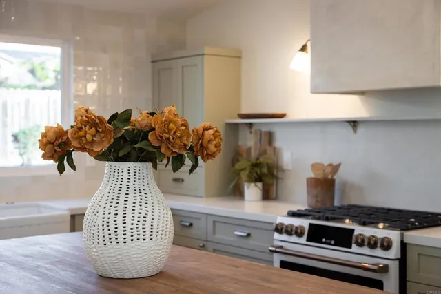 a kitchen with a stove and a white wooden cabinets