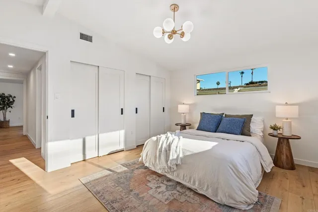 a bedroom with a bed and a chandelier