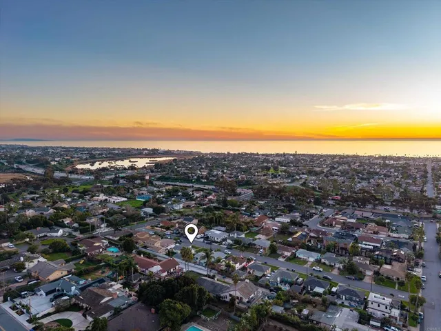 an aerial view of residential houses with city and ocean view