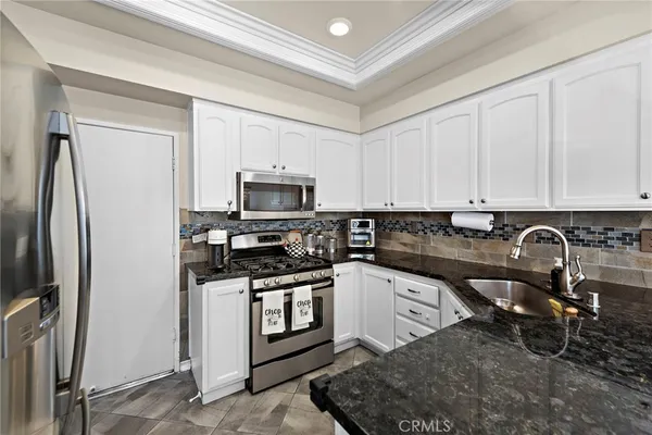 a kitchen with stainless steel appliances granite countertop a refrigerator sink and stove