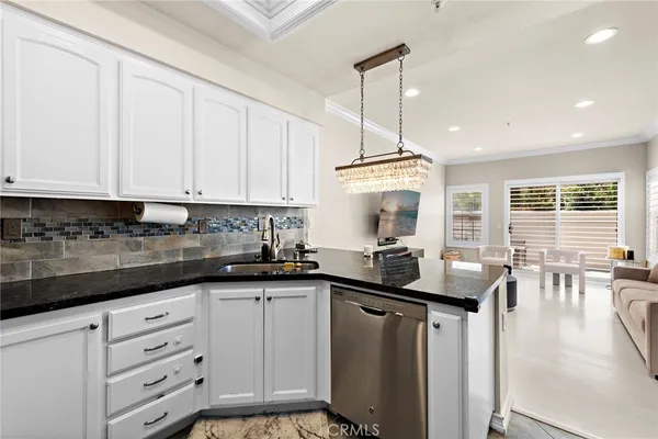a kitchen with granite countertop a sink a stove and cabinets