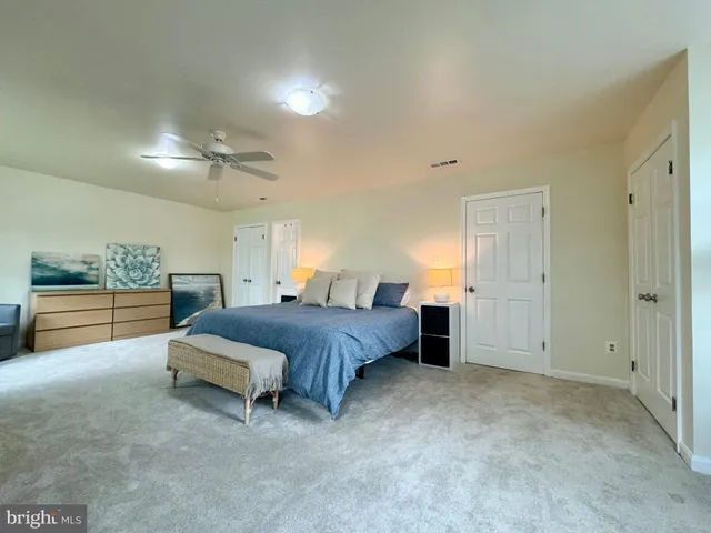 a spacious bedroom with a bed and a cabinets