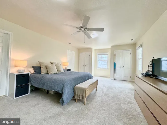 a spacious bedroom with a bed and a flat screen television