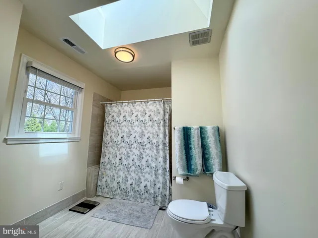 a bathroom with a toilet and a shower