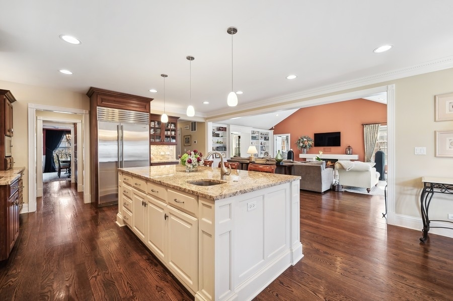 632 Chatham Road Glenview, IL 60025 - Photo 12 of 52 a large kitchen with stainless steel appliances kitchen island granite countertop a large center island attached withe living room