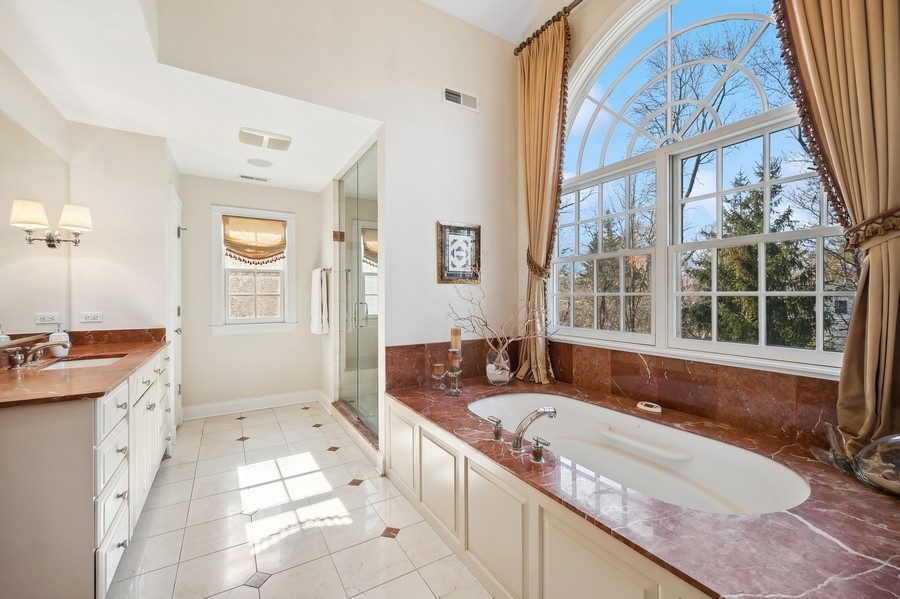 632 Chatham Road Glenview, IL 60025 - Photo 23 of 52 a spacious bathroom with a granite countertop tub sink and mirror