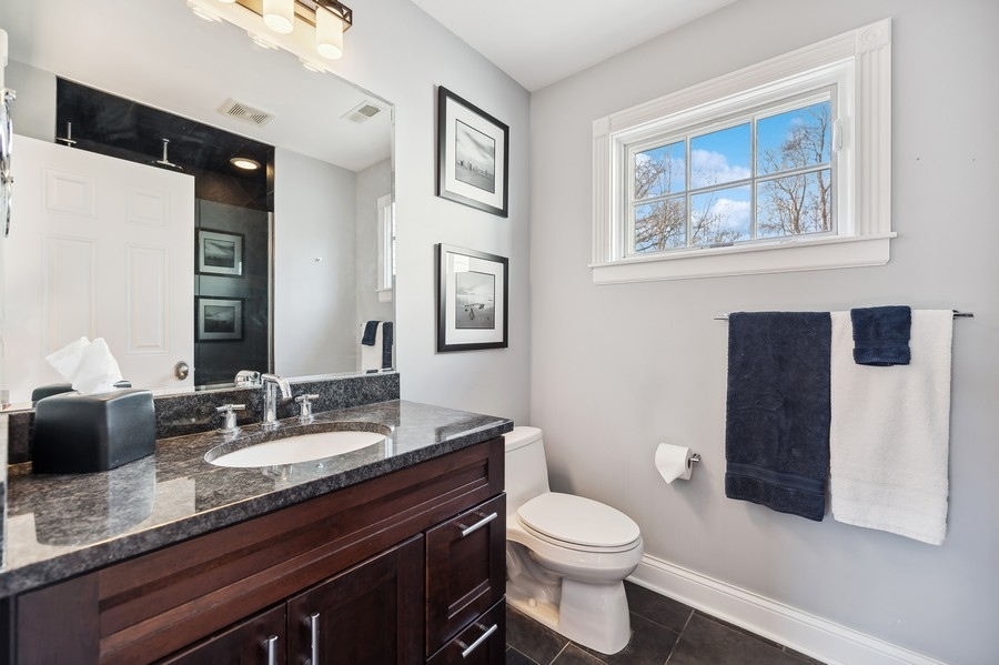 632 Chatham Road Glenview, IL 60025 - Photo 27 of 52 a bathroom with a granite countertop toilet sink and mirror