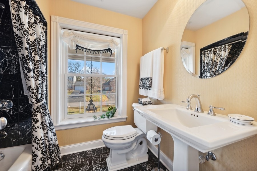 632 Chatham Road Glenview, IL 60025 - Photo 29 of 52 a bathroom with a sink a toilet and a large mirror