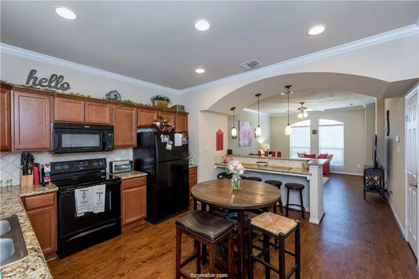 a kitchen with stainless steel appliances a dining table and chairs