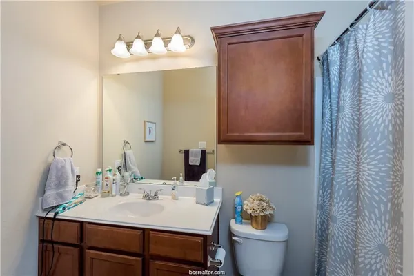 a bathroom with a sink vanity mirror and toilet