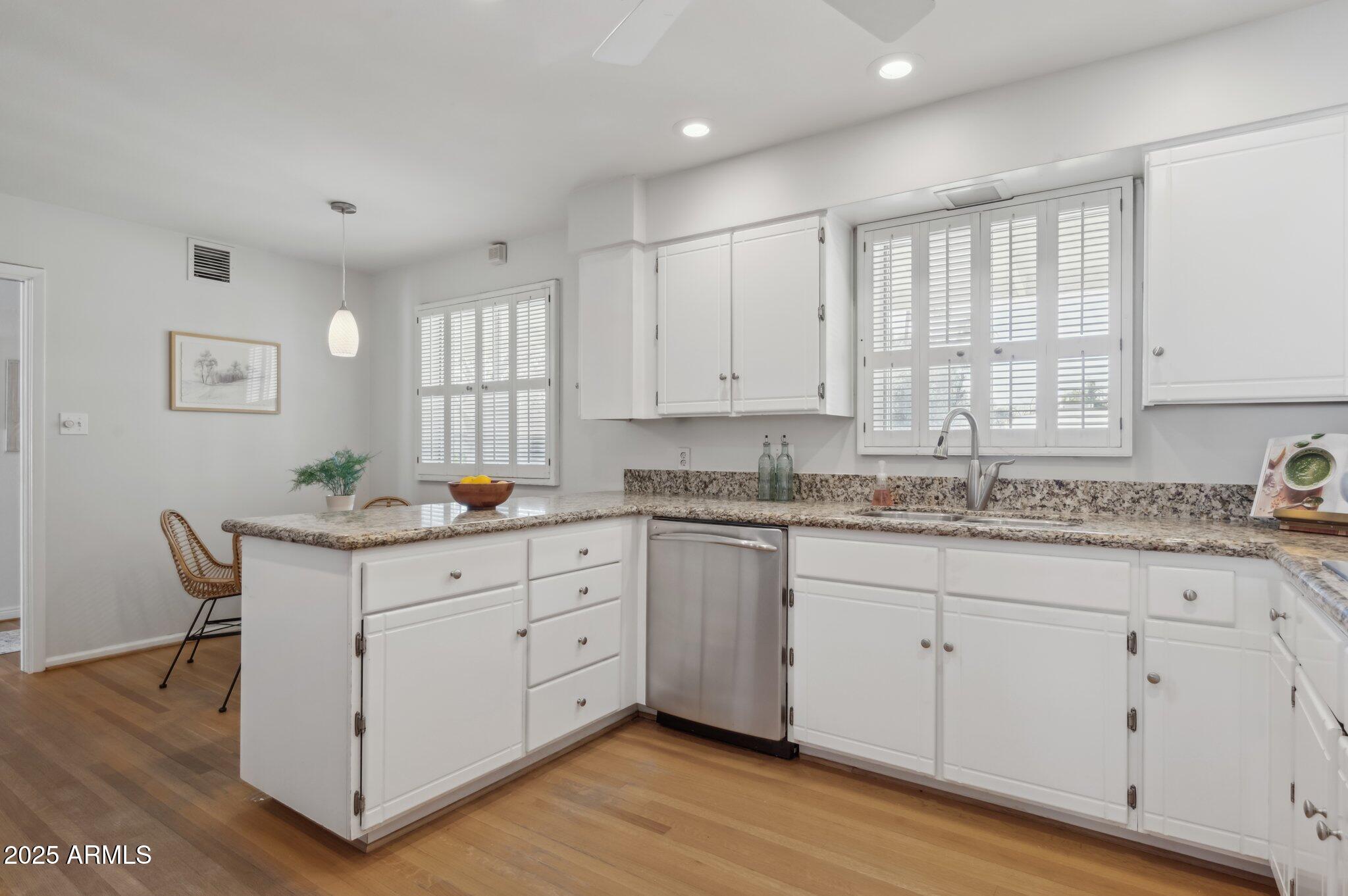 602 West Palmaire Avenue Phoenix, AZ 85021 - Photo 11 of 33 a kitchen with granite countertop white cabinets white appliances a sink and a window