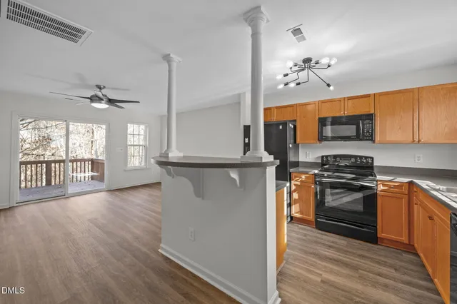 a kitchen with stainless steel appliances granite countertop a stove top oven a sink and dishwasher with wooden floor