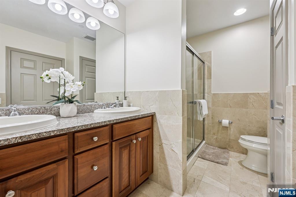 7400 River Road, Unit 409 North Bergen, NJ 07047 - Photo 12 of 30 a spacious bathroom with a granite countertop sink a toilet a mirror and shower