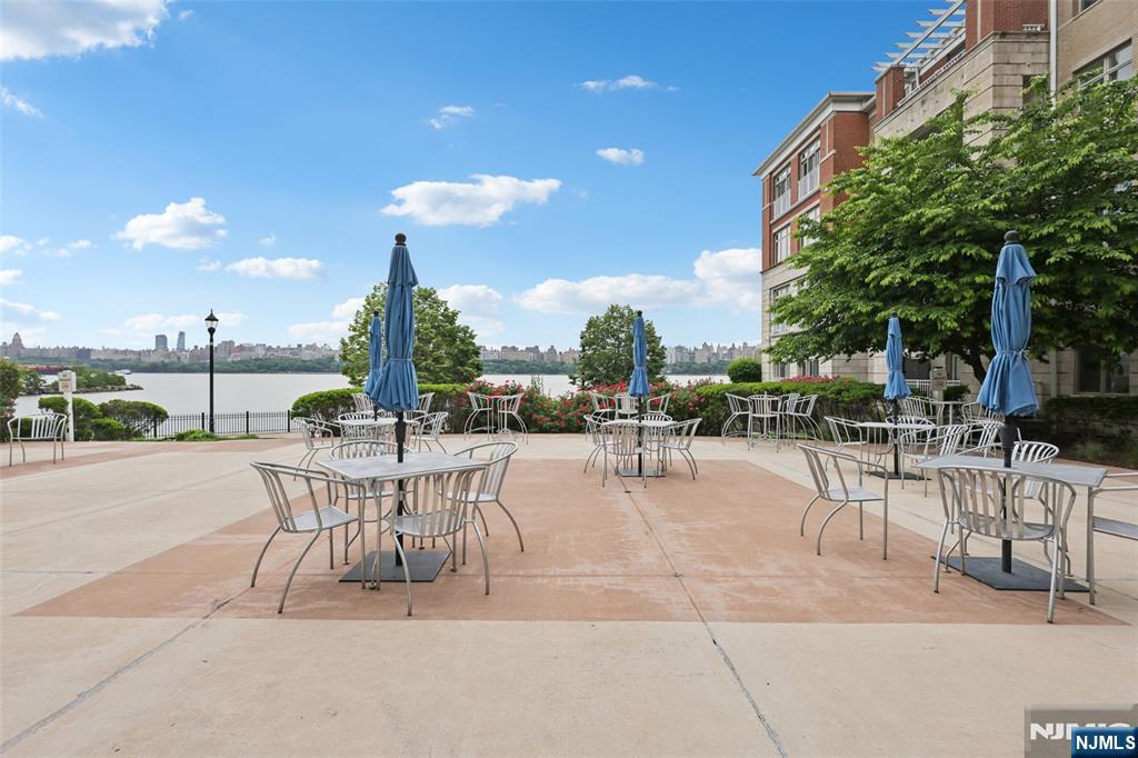 7400 River Road, Unit 409 North Bergen, NJ 07047 - Photo 24 of 30 a view of a patio with dining table and chairs with a patio