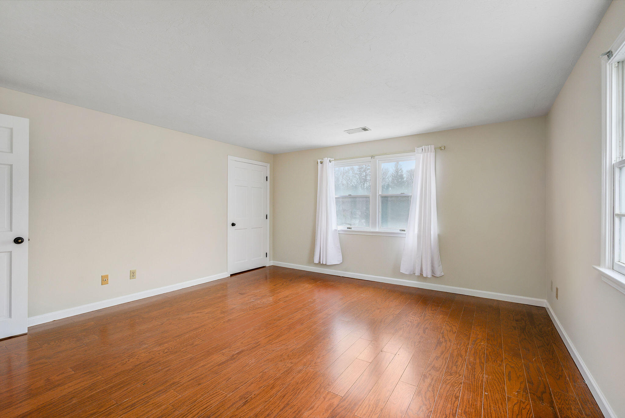 727 Main Street, Unit C3 Osterville, MA 02655 - Photo 14 of 23 an empty room with wooden floor and windows