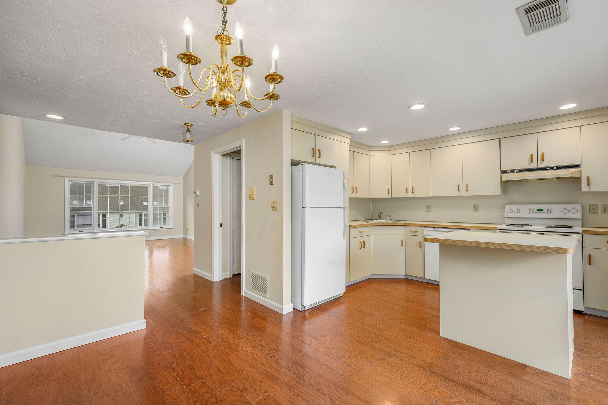 727 Main Street, Unit C3 Osterville, MA 02655 - Photo 8 of 23 a kitchen with white cabinets and chandelier