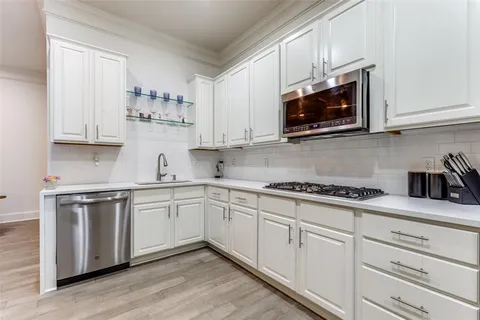a kitchen with white cabinets and appliances
