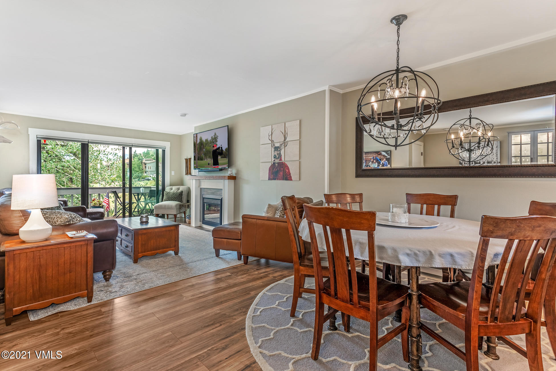 a view of a dining room with furniture a chandelier and wooden floor