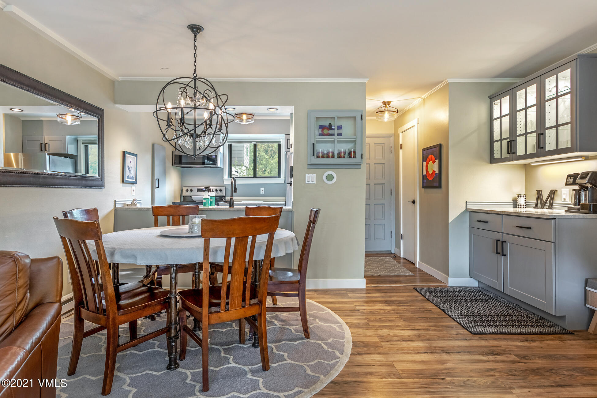 980 Vail View Drive, Unit 211B Vail, CO 81657 - Photo 3 of 21 a view of a dining room with furniture a chandelier and wooden floor
