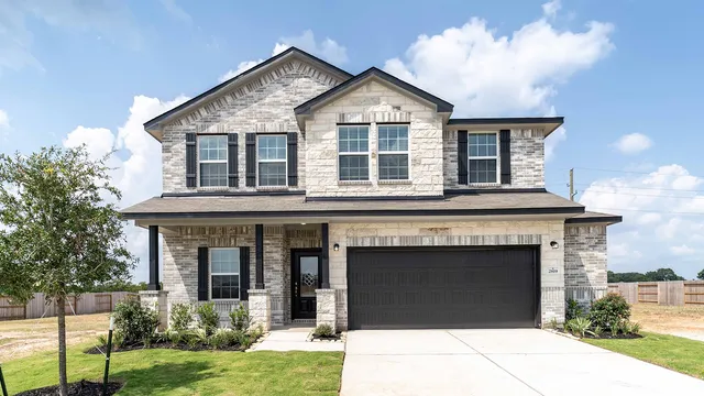 a front view of a house with a garden and yard