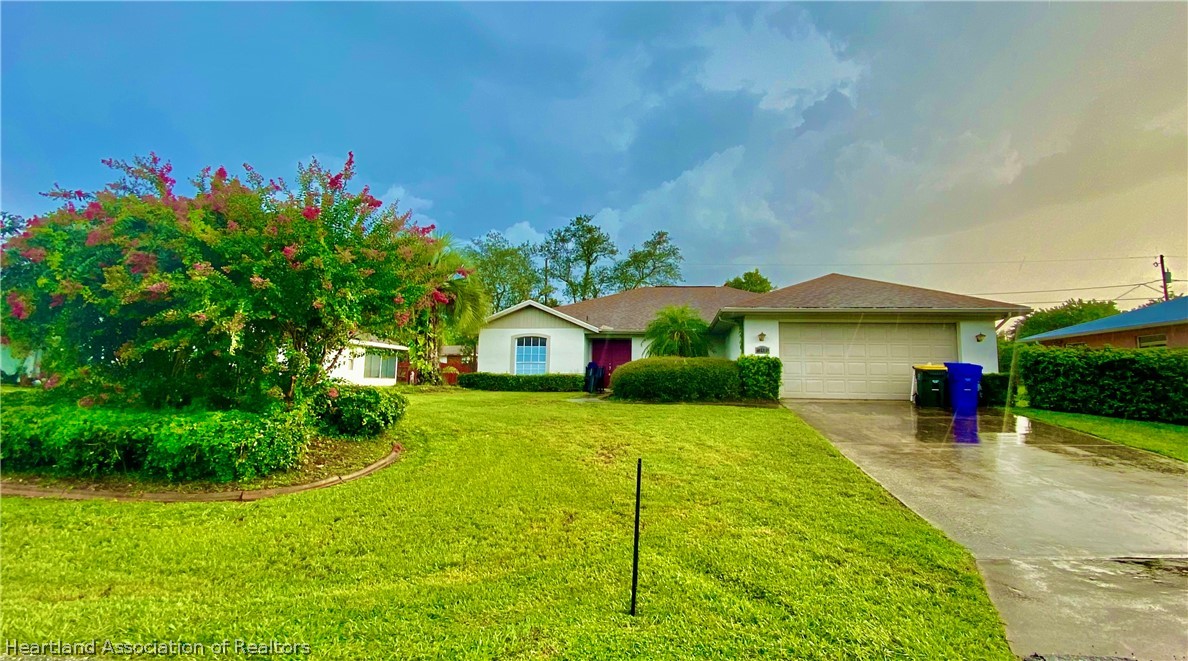 248 Tangerine Road Lake Placid, FL 33852 - Photo 1 of 16 a front view of a house with a yard and garage