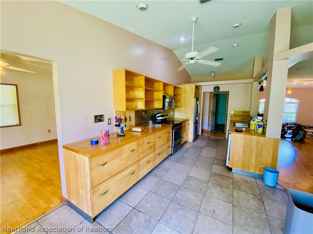 248 Tangerine Road Lake Placid, FL 33852 - Photo 5 of 16 a large kitchen with kitchen island granite countertop a large counter top and stainless steel appliances