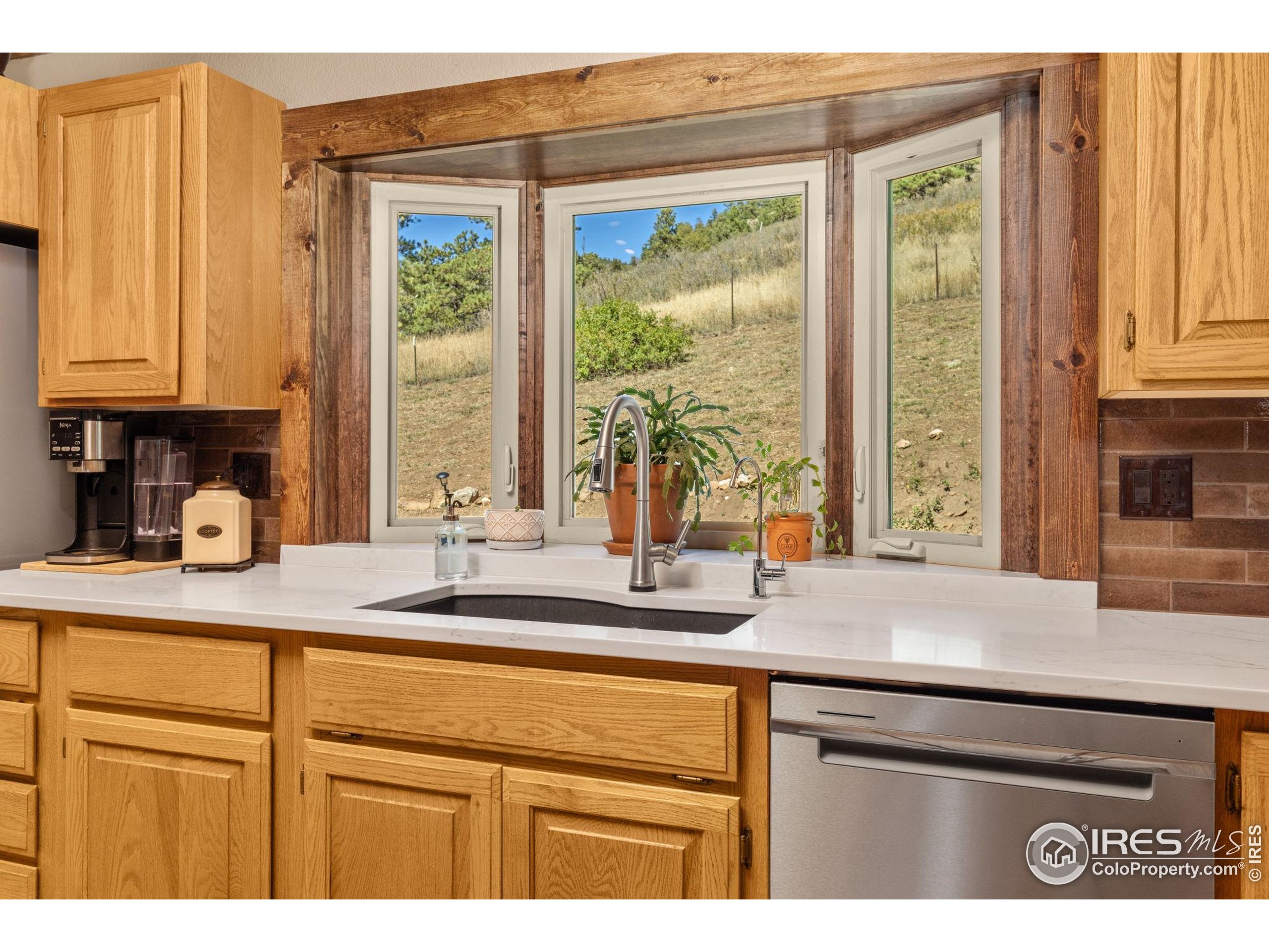 681 Bitterroot Gulch Road Loveland, CO 80537 - Photo 13 of 47 a kitchen with stainless steel appliances granite countertop a sink and a window