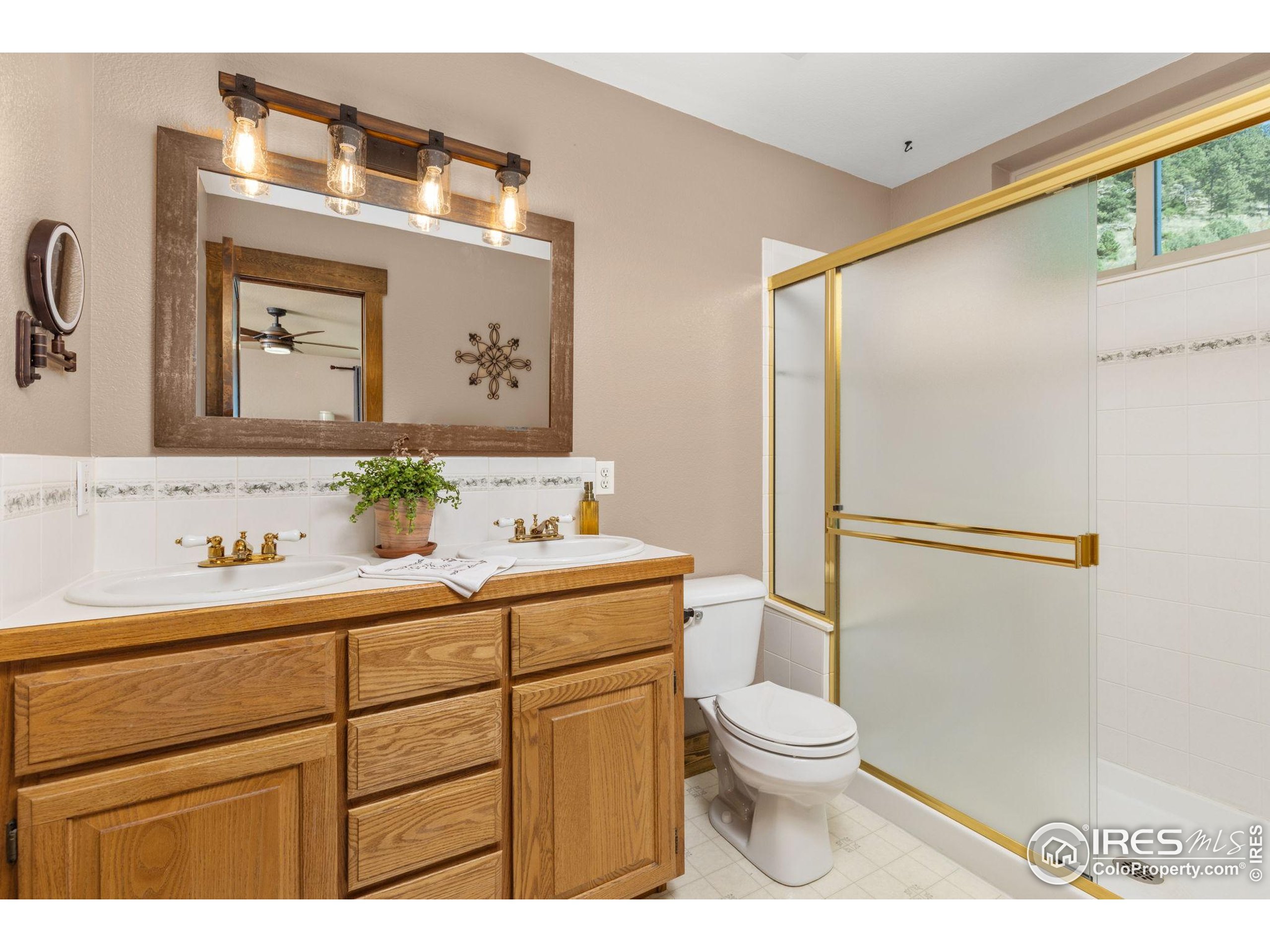 681 Bitterroot Gulch Road Loveland, CO 80537 - Photo 20 of 47 a bathroom with a toilet a sink and a mirror